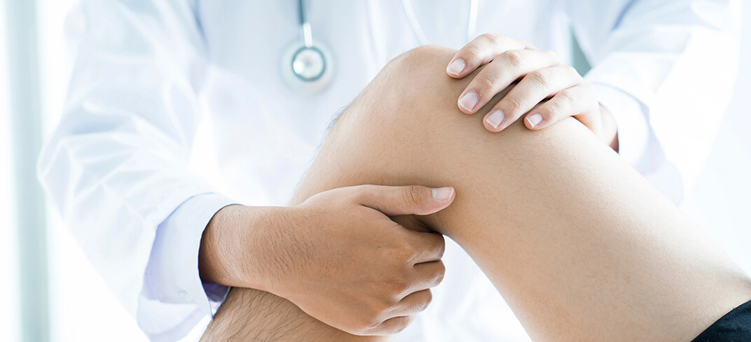 Medico che esamina il ginocchio del paziente