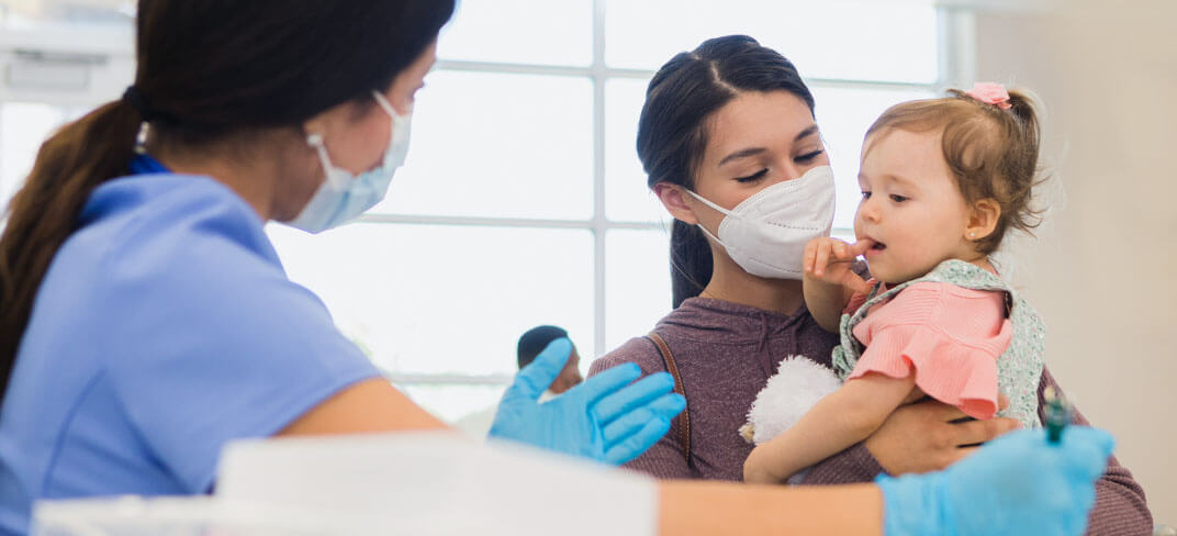 Mom holding baby and woman provider holding her arms out to her